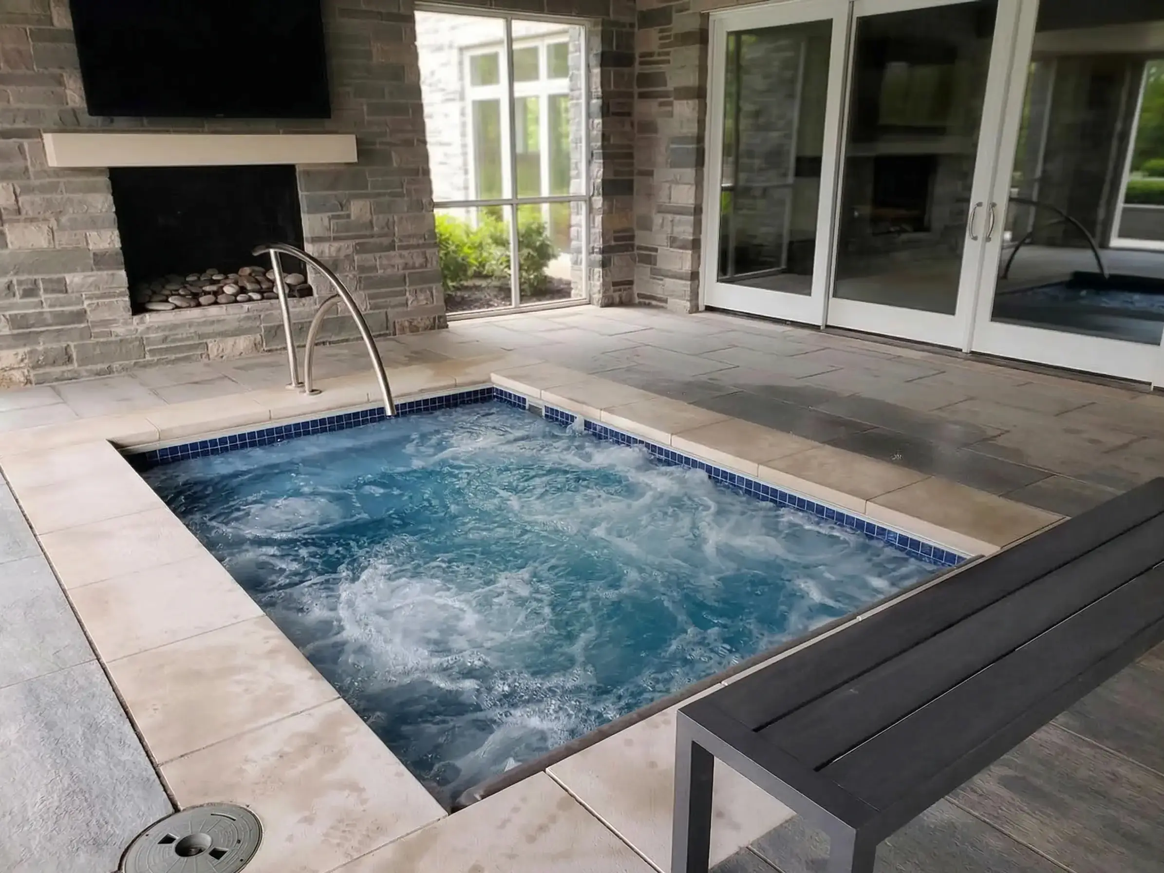 Covered patio with hot tub and fireplace