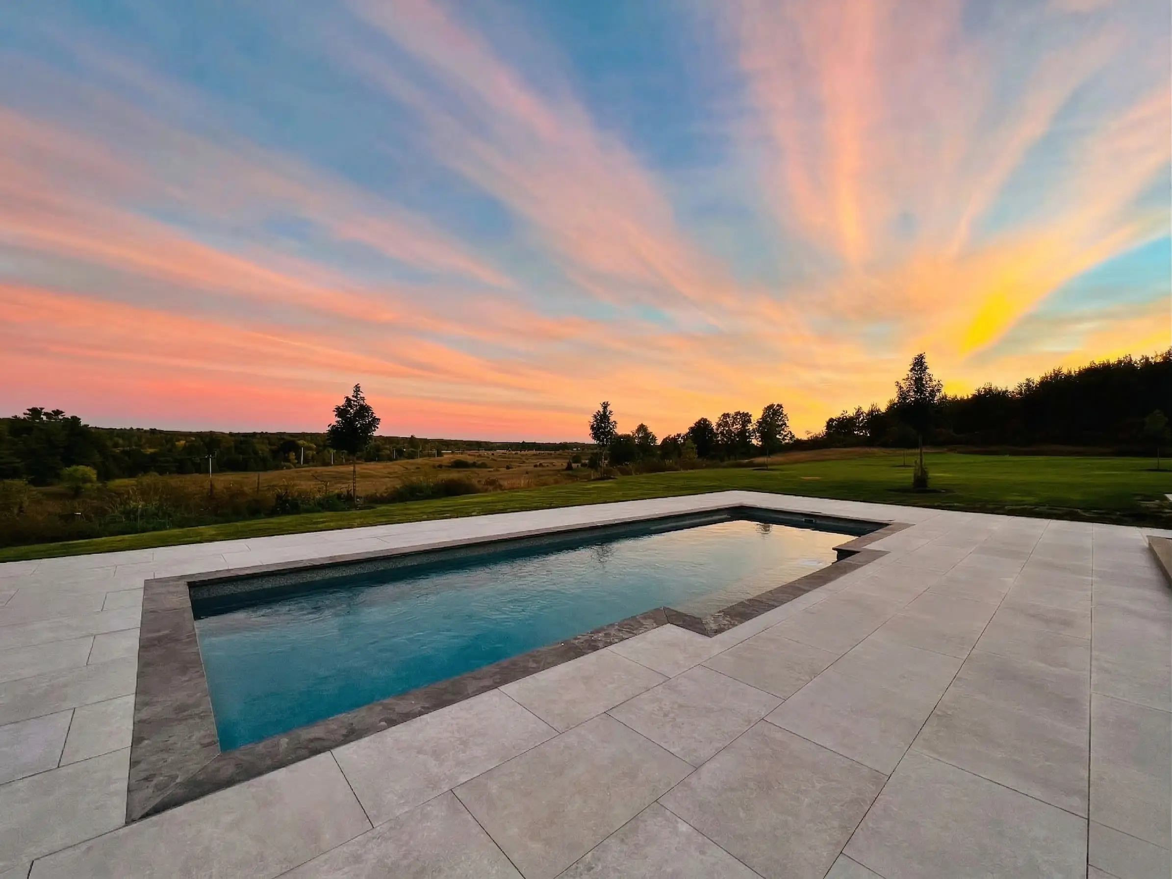 Modern pool reflecting sunset sky