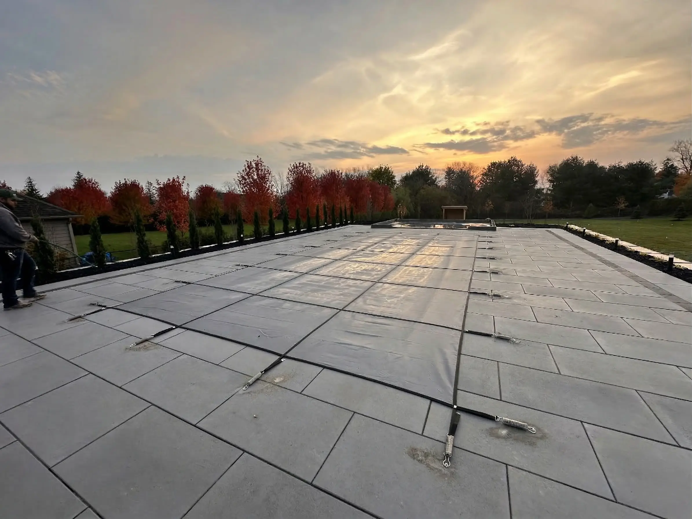 Pool with safety cover at autumn sunset